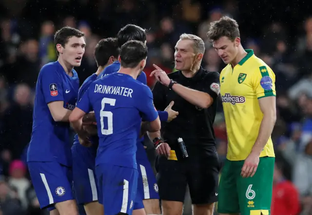 Chelsea players argue with the referee