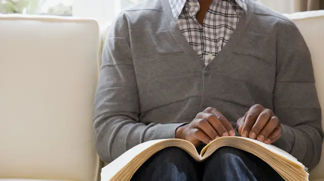 Blind man reading a braille book