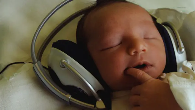 A baby listens to music