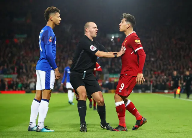 Mason Holgate and Roberto Firmino are separated by referee Robert Madley