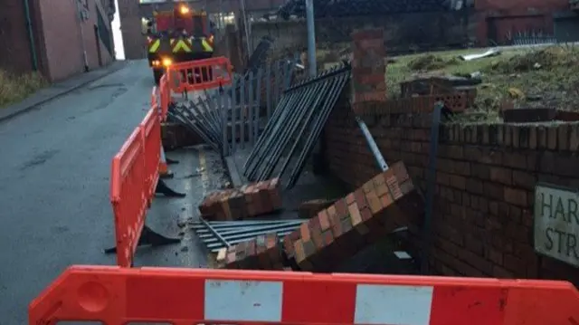 Fencing and wall after falling into road