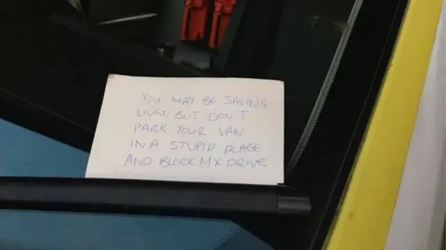 Angry note on ambulance windscreen that says: "You may be saving lives but don't park your van in a stupid place and block my drive."