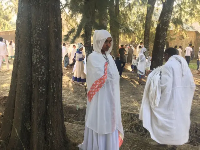 Timkat festival - a woman stands alone, looking at the camera