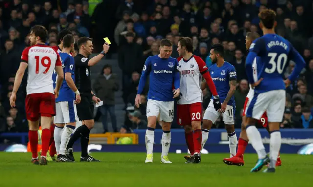 Theo Walcott is shown a yellow card