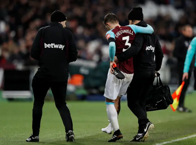 Aaron Cresswell is helped off by medical staff