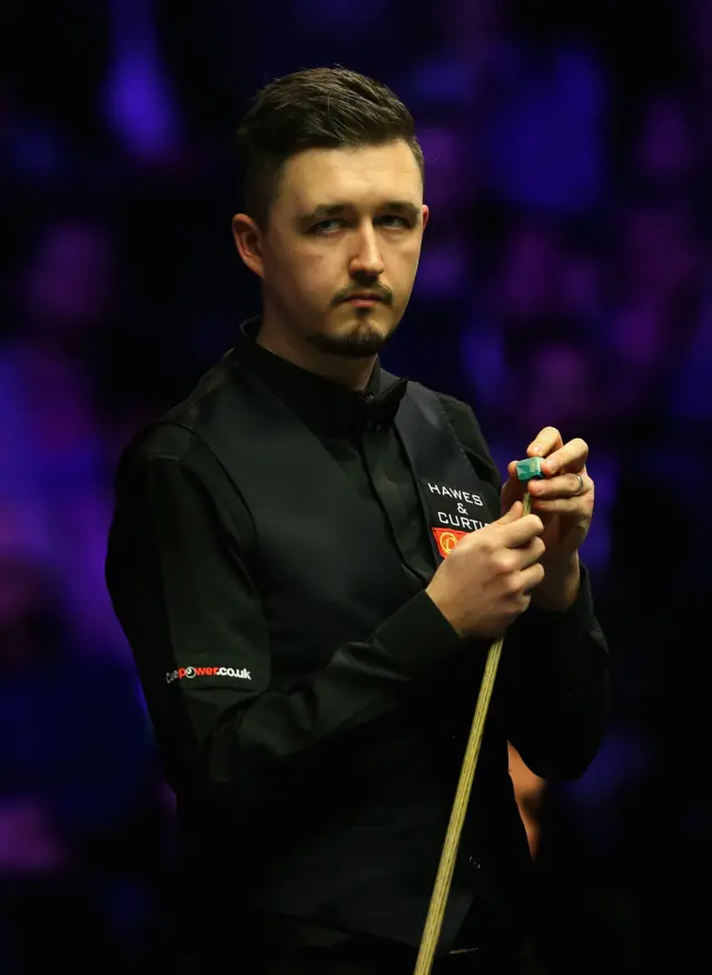 Kyren Wilson chalks his que