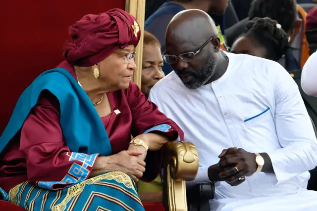 Liberia's outgoing president Ellen Johnson Sirleaf (L) listens to Liberia's President-elect George Weah, during Weah's swearing-in ceremony on January 22, 2018 in Monrovia's stadium.