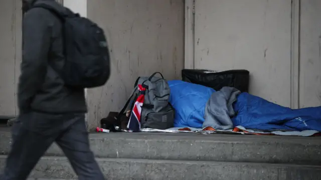 A homeless person sleeping in a corner