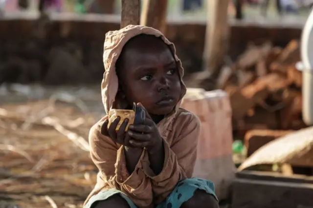 A South Sudanese child fleeing from recent fighting in Lasu in South Sudan holds a candle after sleeping the night outside after crossing the border into the Democratic Republic of Congo, near Aba, on December 23, 2017