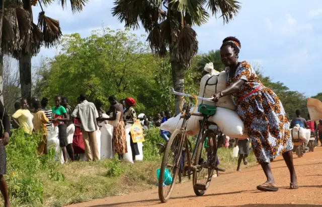 A refugee from South Sudan Kiden Alice Hope transports food she received from the World Food Program (WFP) in Palorinya settlement camp for distribution in Moyo district northern Uganda October 26, 2017