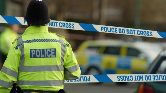 A policeman outside a police cordon