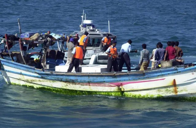 An undated picture shows Yemeni coast guards checking a small boat with refugees arriving from Somalia to the Yemeni port city Aden