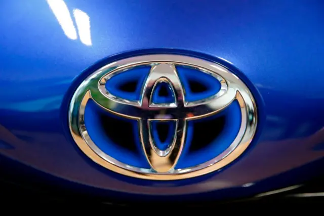 The Toyota company logo is seen on a Yaris model car that is on display at Toyota's automobile manufacturing plant before the visit by the French president in Onnaing, northern France, on January 22, 2018.