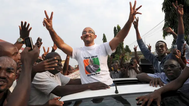 Ivory coast former president Laurent Gbagbo's son Michel Gbagbo waves from a car as he arrives on August 6, 2013 at his father's party FPI headquarters in Abidjan, a day after being released on bail along with 13 aides of Gbagbo, after being detained in the aftermath of Ivory Coast's deadly 2011 crisis.