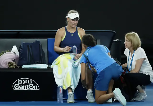 aroline Wozniacki of Denmark receives medical attention