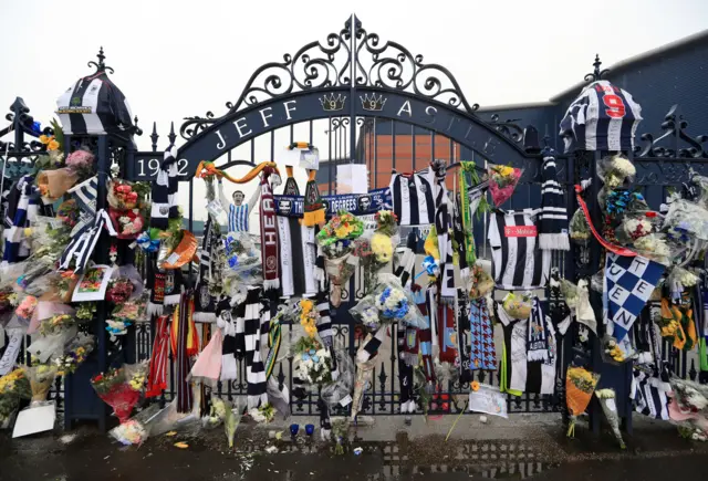 Scarves and flowers on a gate at The Hawthorns stadium