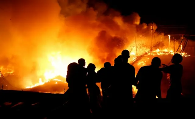 Residents pour water as they attempt to extinguish a fire that broke out at the Kijiji slum in Southlands estate of Nairobi, Kenya January 28, 2018.