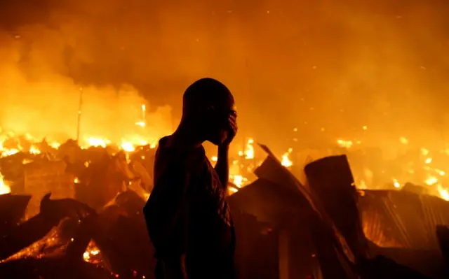 A resident reacts as he attempts to extinguish a fire that broke out at the Kijiji slums in the Southlands estate of Nairobi, Kenya, January 28, 2018.