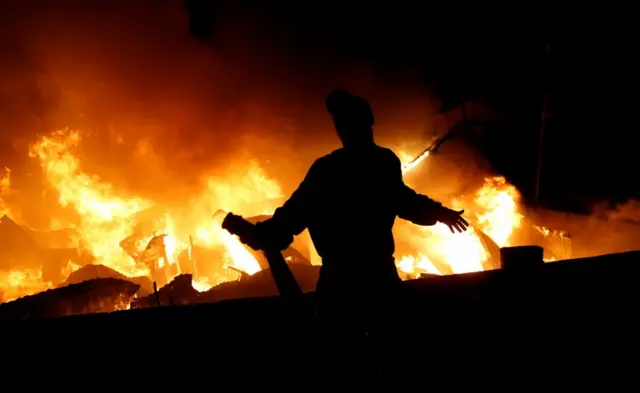 A resident reacts after running out of water as they attempt to extinguish a fire that broke out at the Kijiji slum in Southlands estate of Nairobi, Kenya January 28, 2018