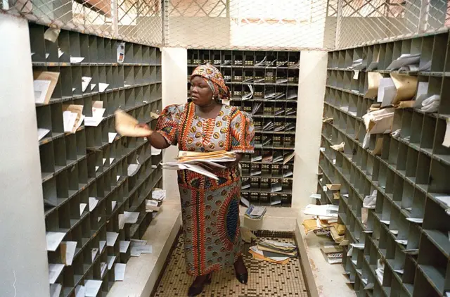 A postal worker sorts out the mail in Ouagadougou 07 December 1999. The different services of Burkina Faso's post office, dealing with some 10,000 letters daily, are not computerized and 'fear more the rats, which eat the documents, than the year 2000 bug.'