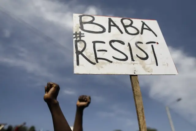 Supporters of the Kenyan opposition National Super Alliance (NASA) and its leader Raila Odinga hold up a placard that reads "Baba (Odinga) Resist" during Odinga"s "swearing-in" ceremony in Nairobi, Kenya, 30 January 2018