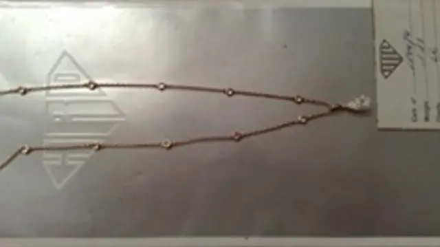 A diamond drop necklace on a gold chain