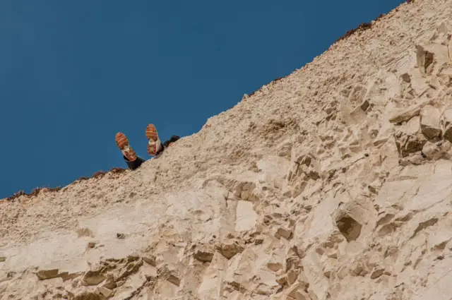 Feet over edge of cliff, Birling Gap