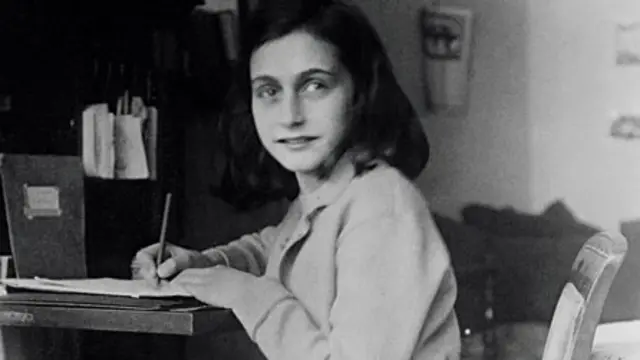 Anne Frank at her desk, aged 12, before the family went into hiding.