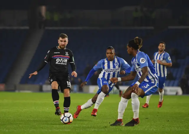 James McArthur of Crystal Palace is faced by Gaetan Bong and Jose Izquierdo of Brighton