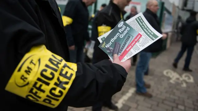 Members of rail staff taking industrial action hand out leaflets