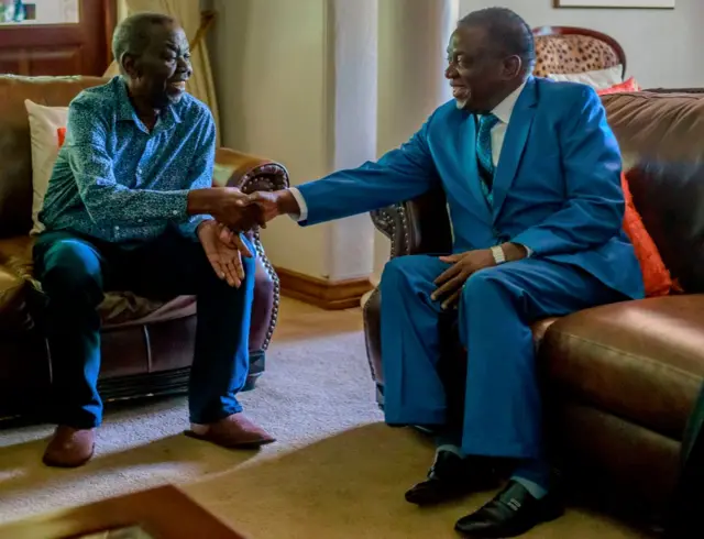 Zimbabwe's President Emmerson Mnangagwa (R) shakes hands with the leader of the Movement for Democratic Change (MDC), the country's main opposition party, Morgan Tsvangirai (L), who has been battling cancer, during a visit at his home in Harare on January 5, 2018.