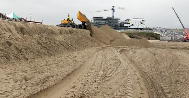 Diggers moving sand around at Perranporth Beach