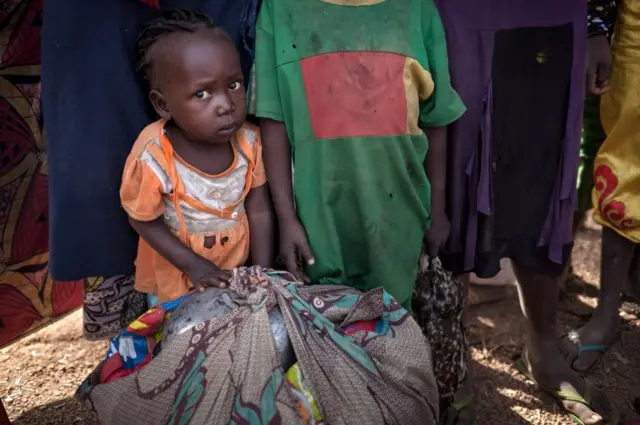 A little girl fleeing, with her family, the threat of attacks on Betoko town, northwestern Central African Republic, poses for a photograph on December 27, 2017.