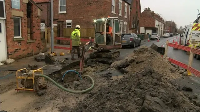 Workmen digging up the road.