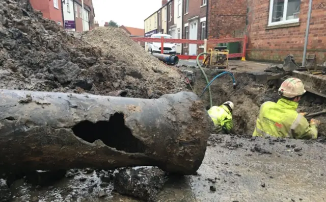 A water pipe with a big hole in it.