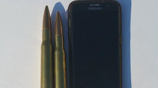 Bullets next to a smartphone for comparison