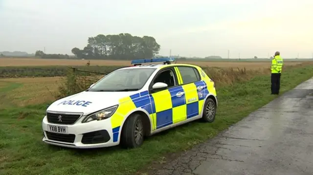 A police officer standing near the field