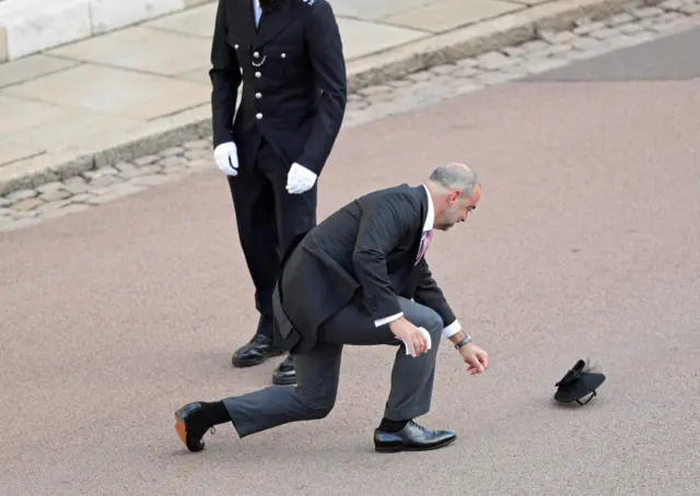 A guest picks up a fascinator from the floor