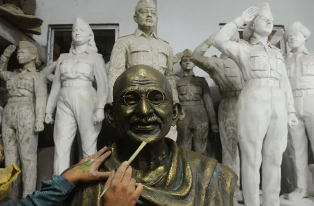 This picture, taken on September 25, 2018, shows an Indian artisan giving final touches on a statue of the father of the nation 'Mahatma Gandhi'