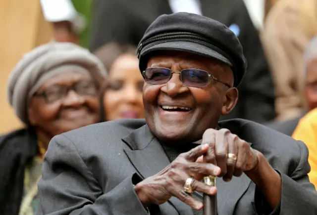 Archbishop Desmond Tutu laughs as crowds gather to celebrate his birthday by unveiling an arch in his honour outside St George"s Cathedral in Cape Town, South Africa, October 7, 2017