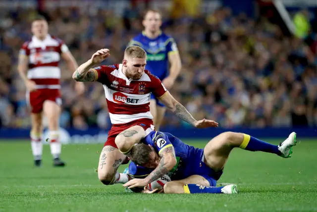 Sam Tomkins clatters into Daryl Clark