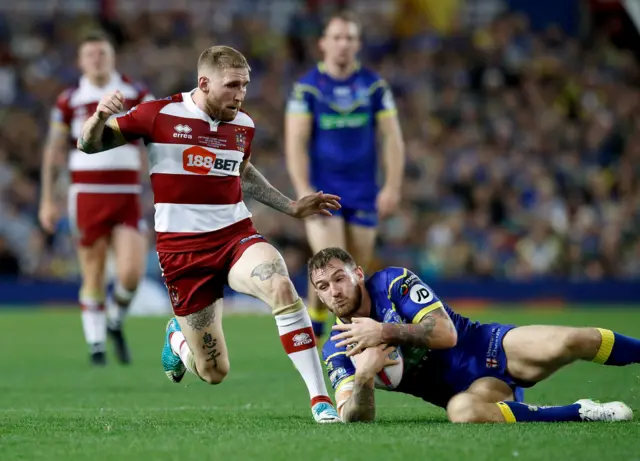 Wigan Warriors' Sam Tomkins clatters into Warrington Wolves' Daryl Clark