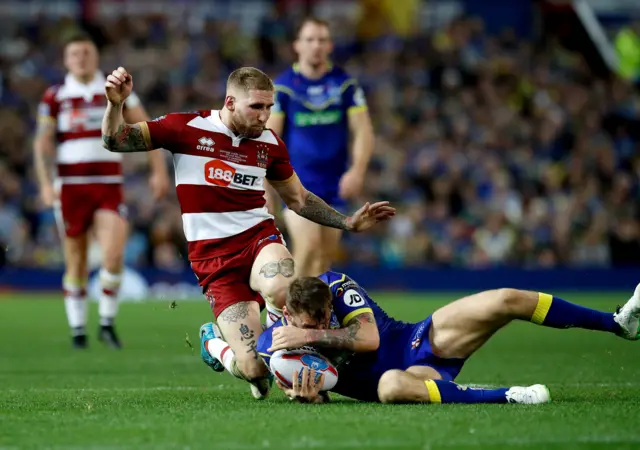 Sam Tomkins clatters into Daryl Clark