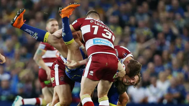 Ben Westwood of Warrington Wolves is tackled by Sean O'Loughin of Wigan Warriors