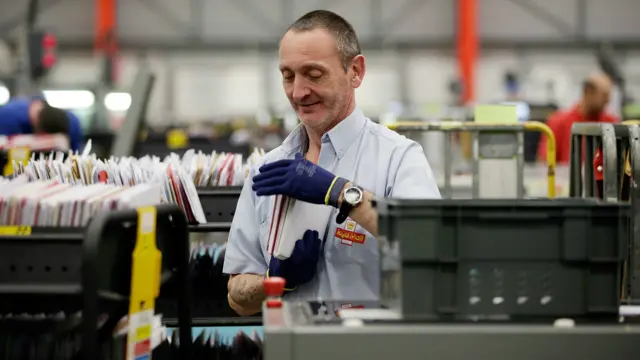 A worker sorts letters