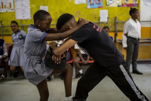 Girls practice self defence methods during a session with NGO Action Breaks Silence (ABS) called "Empowerment through self-defence for women and girls" which aims to create a world free form fear of gender based violence, at Mbuyisa Makhubu Primary School in the are of Orlando West, in the South African township of Soweto, on October 10, 2018.