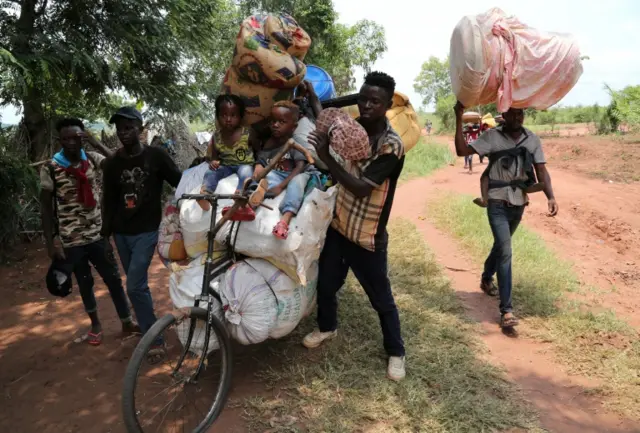 Congolese migrants expelled from Angola push a rented bicycle to transport their children and belongings along the road to Tshikapa, Kasai province near the border with Angola, in the Democratic Republic of the Congo, October 12, 2018