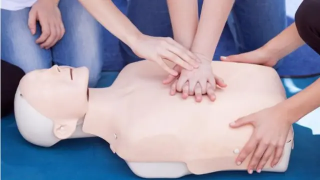 A person using a CPR dummy