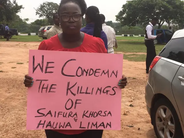 Woman holding up a sign