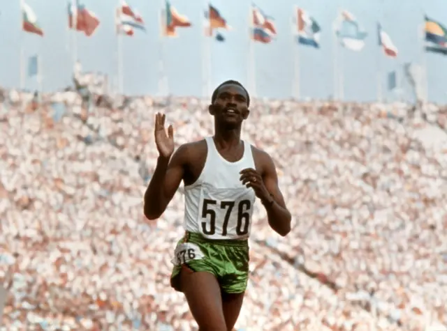 Kipchoge Keino waves to crowd after crossing the finish line of the Olympics 3000m steeplechase, Munich 05 September 1972.